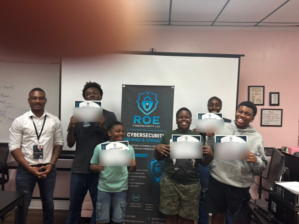 An instructor stands with a group of young students, each holding an ROE Cybersecurity certificate, in front of an ROE Cybersecurity LLC banner